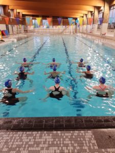 Group of synchronised swimmers in a swimming pool